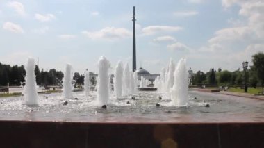 Moskova Rusya 'da açık bir yaz gününde Poklonnaya tepesindeki anıt kule manzaralı su çeşmesi.