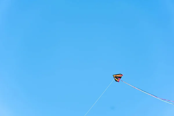 Летящий змей с голубым небом на фоне — стоковое фото