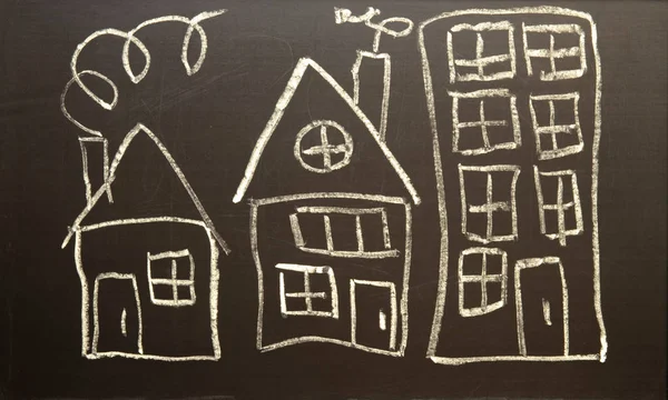 Children\'s drawing of houses drawn in chalk on a black board