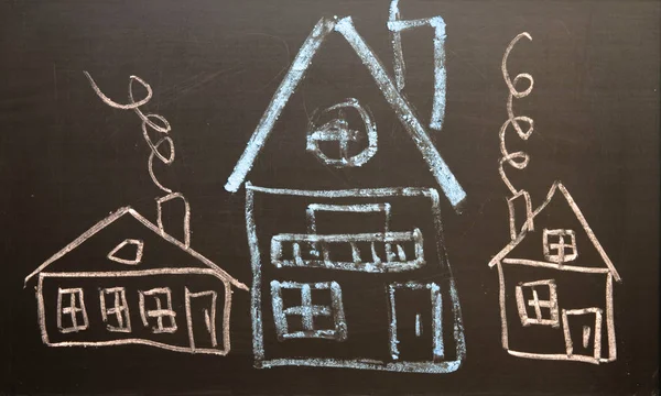 Children\'s drawing of houses drawn in chalk on a black board