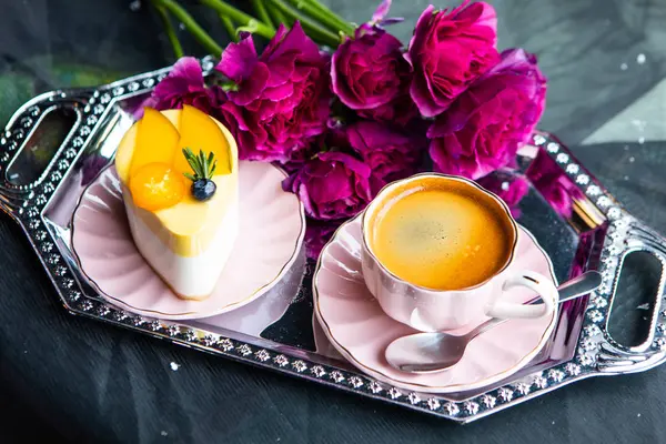 Uçan daire Metal tepsi üzerinde üstten görünüm taze kahve espresso pembe kupa ve lezzetli pasta. Bir buket çiçek arka planda