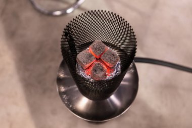 Nargile, Delikli Folyo ile Kaplı bir seramik kase üzerinde yanan sıcak kömürler Top View. Kase bir kafes kalkanı ile korunmaktadır