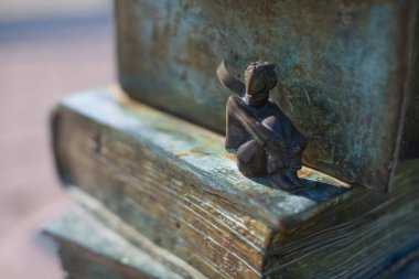 Saint Petersburg, Rusya - 10 Ağustos 2018: küçük bir prensin (Le Petit Prince) küçük romantik heykeli, devlet Üniversitesi'nin avlusunda bir kitap yığınının üzerinde oturup rüya gördü. Seçici odaklama