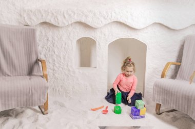 Tuz Mağarası İçindeki Çocuk Oyun Evi'nde Kum Havuzu İçin Renkli Oyuncaklarla Oyun Oynayan Küçük Kız