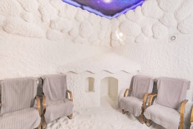 Tuz Mağarası İç Çocuk Oyunları için Küçük Bir Ev. Dokulu Duvarlar ve Müşteriler için Sandalyeler ve Onların Çocuklar için Playhouse ile Haloterapi Oturumları Için Oda.