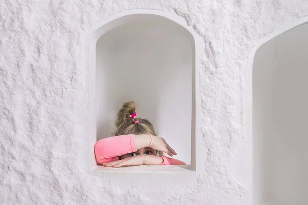 Tuz Mağarası'nın İçindeki Çocuk Oyun Evi'nde oynayan küçük kız. Gizleme Yüzü, Onun Clasped Hands Through Peeping, Kamera Bakıyor