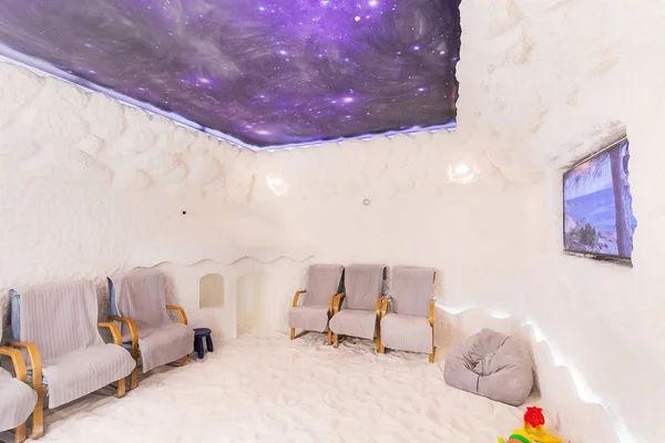 Salt Cave Interior With Textured Walls. Room For Halotherapy Sessions With Chairs For Patients, Children\'s Playhouse And TV-set.