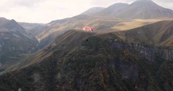 Paraglider Vliegen over bergen op zomerdag. Extreme sport in de Kaukasus. — Stockvideo