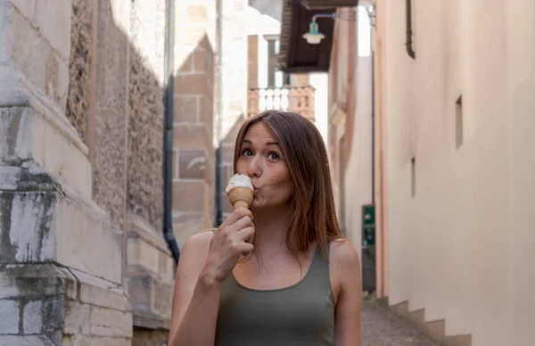 young woman eating ice cream in an alley