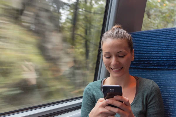 young woman text messaging with his smartphone during a journey