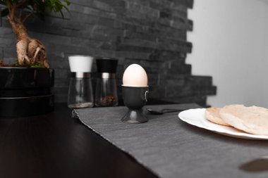 Fruehstueck mit Ei modern schwarz grau Steinwand