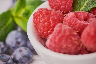 yaban mersini ile beyaz bir kase içinde ahududu