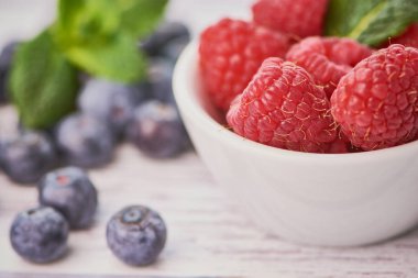 yaban mersini ile beyaz bir kase içinde ahududu