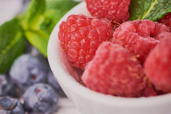 yaban mersini ile beyaz bir kase içinde ahududu