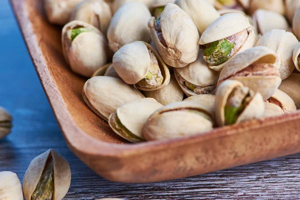 ahşap yüzey üzerinde ahşap bir kase fıstık makro fotoğraf