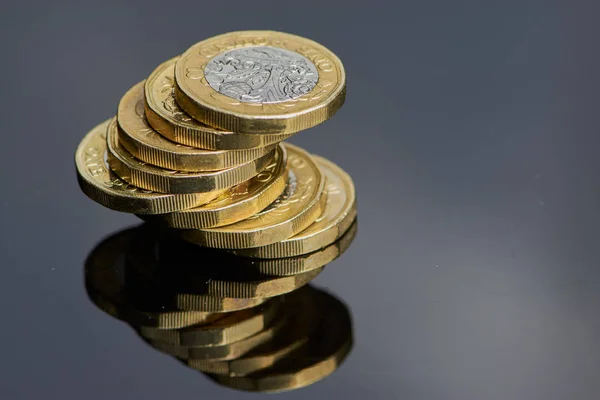 Siyah Cam altında yansıması ile kullanılan İngiliz bir pound Sterlini sikke yığını