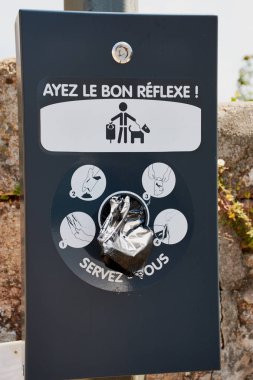 Benodet, Fransa - 07 Temmuz 2018: Brittany, Fransa Audierne içinde köpek atık torbaları için istasyonu Fransızca. Metin anlamına gelir: 