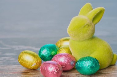 ahşap arka plan karşı çikolata yumurta ile yeşil Paskalya tavşanı