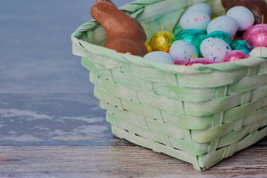 ahşap bir zemin üzerine yeşil Paskalya sepeti