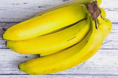 beyaz ahşap bir masa üzerinde muz demet