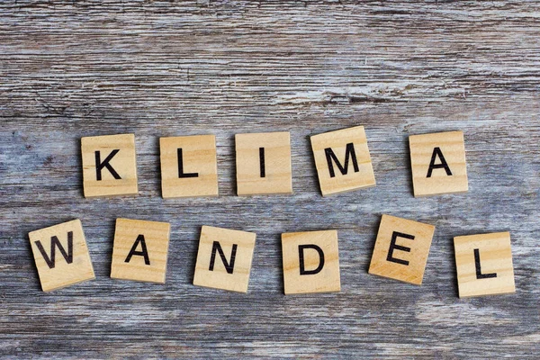 the German word means climate change in English, laid with wooden capital letters on wooden background
