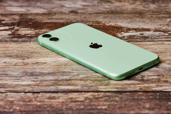 Tahta arka planda yeni yeşil Apple iPhone 11.
