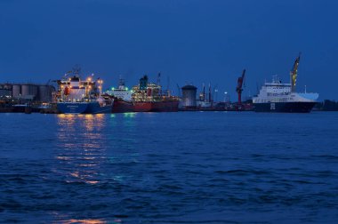 Vlaardingen, Hollanda - 10 Ağustos 2020: Hollanda 'nın Vlaardingen kentindeki sanayi limanında mavi saat boyunca üç gemi.