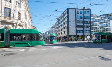 Basel, İsviçre - 2 Eylül 2025: İsviçre 'nin Basel kentindeki Aeschenplatz' da üç ikonik yeşil tramvay birleşiyor. 