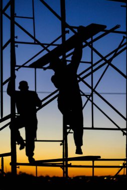 Operarios em andaimes na construcao
