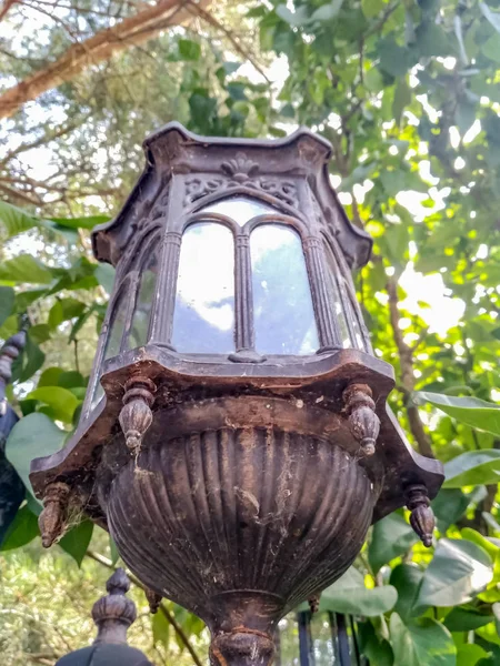 Antigua lámpara de calle vintage rota se levanta sobre un fondo de madera verde — Foto de Stock