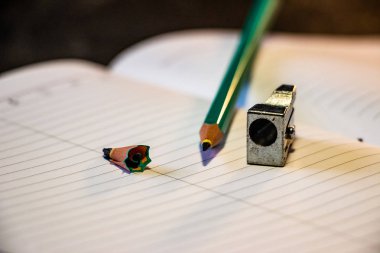 Keskinleştirilmiş kalem bir defter, üst görünüm üzerinde yatıyor. Siyah arka plan. Kalem planlayıcı. Close