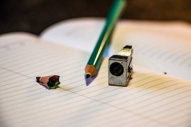 Keskinleştirilmiş kalem bir defter, üst görünüm üzerinde yatıyor. Siyah arka plan. Kalem planlayıcı. Close