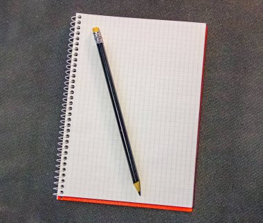 Tasarım konsepti - kırmızı ve gri spiral defter ve siyah kalem koleksiyonunun siyah arka plan üzerindeki görünümü.