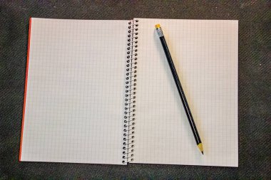 Tasarım konsepti - kırmızı ve gri spiral defter ve siyah kalem koleksiyonunun siyah arka plan üzerindeki görünümü.