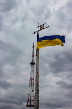 Ukrayna bayrağı bulut ile gri gökyüzü bir arka plan üzerinde sallayarak