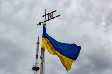 Ukrayna bayrağı bulut ile gri gökyüzü bir arka plan üzerinde sallayarak