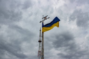 Ukrayna bayrağı bulut ile gri gökyüzü bir arka plan üzerinde sallayarak