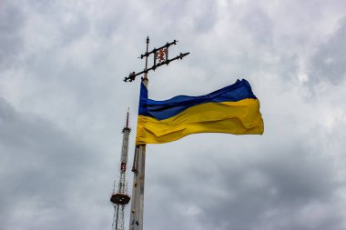 Ukrayna bayrağı bulut ile gri gökyüzü bir arka plan üzerinde sallayarak