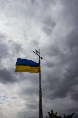 Ukrayna bayrağı bulut ile gri gökyüzü bir arka plan üzerinde sallayarak