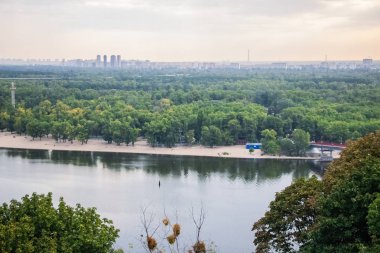 Avrupa 'nın merkezinde Kiev turu. Dinyeper manzarası, Trukhanov adası ve bir ayak köprüsü. Park çeşmesi ve gün batımı ufukta.