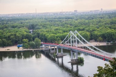 Avrupa 'nın merkezinde Kiev turu. Dinyeper manzarası, Trukhanov adası ve bir ayak köprüsü. Park çeşmesi ve gün batımı ufukta.