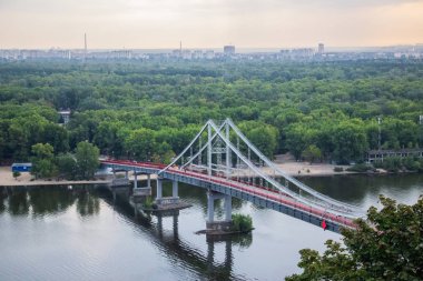 Avrupa 'nın merkezinde Kiev turu. Dinyeper manzarası, Trukhanov adası ve bir ayak köprüsü. Park çeşmesi ve gün batımı ufukta.