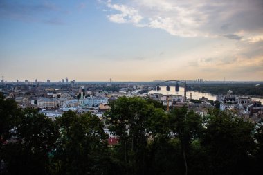 Avrupa 'nın merkezinde Kiev turu. Dinyeper manzarası, Trukhanov adası ve bir ayak köprüsü. Park çeşmesi ve gün batımı ufukta.