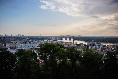 Avrupa 'nın merkezinde Kiev turu. Dinyeper manzarası, Trukhanov adası ve bir ayak köprüsü. Park çeşmesi ve gün batımı ufukta.