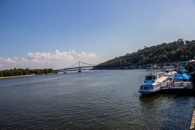 Avrupa 'nın merkezinde Kiev turu. Dinyeper manzarası, Trukhanov adası ve bir ayak köprüsü. Park çeşmesi ve gün batımı ufukta.