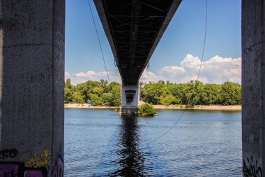 Avrupa 'nın merkezinde Kiev turu. Dinyeper manzarası, Trukhanov adası ve bir ayak köprüsü. Park çeşmesi ve gün batımı ufukta.