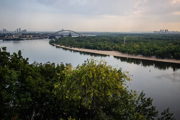 Tour of Kiev in the center of Europe. View of the Dnieper, Trukhanov island and a foot bridge. Park fountain and sunset on the horizon