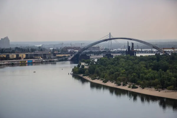 Tour of Kiev in the center of Europe. View of the Dnieper, Trukhanov island and a foot bridge. Park fountain and sunset on the horizon