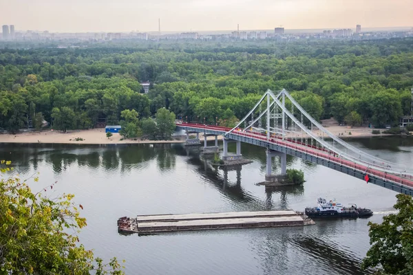 Tour of Kiev in the center of Europe. View of the Dnieper, Trukhanov island and a foot bridge. Park fountain and sunset on the horizon