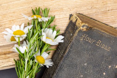 Eski İncil, biberiye, yabani çiçekler, basit zamanların basit görüntüsü, sert ahşap üzerinde duran eski bir İncil biberiye ve kır çiçekleri.